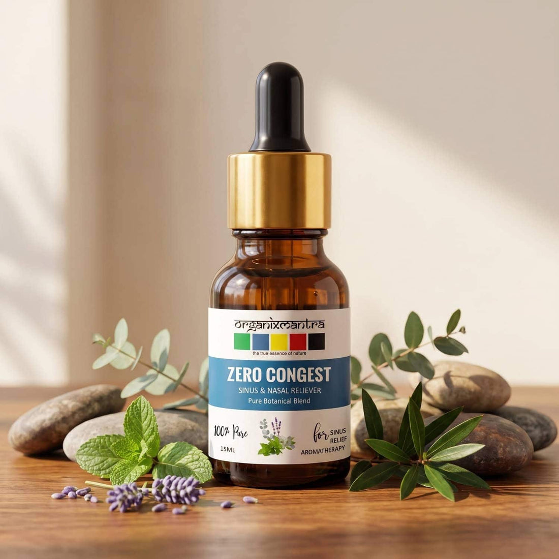 Zero Congest 15 ml amber dropper bottle on wood with eucalyptus, mint and lavender sprigs and smooth grey pebbles